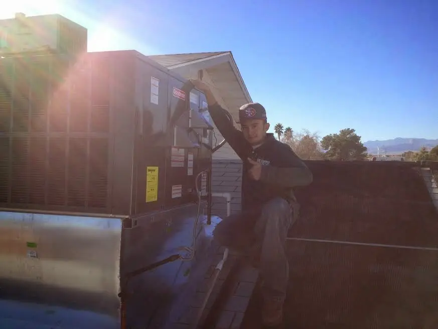 HVAC technician performing Air Duct Cleaning on a rooftop unit in Champlin